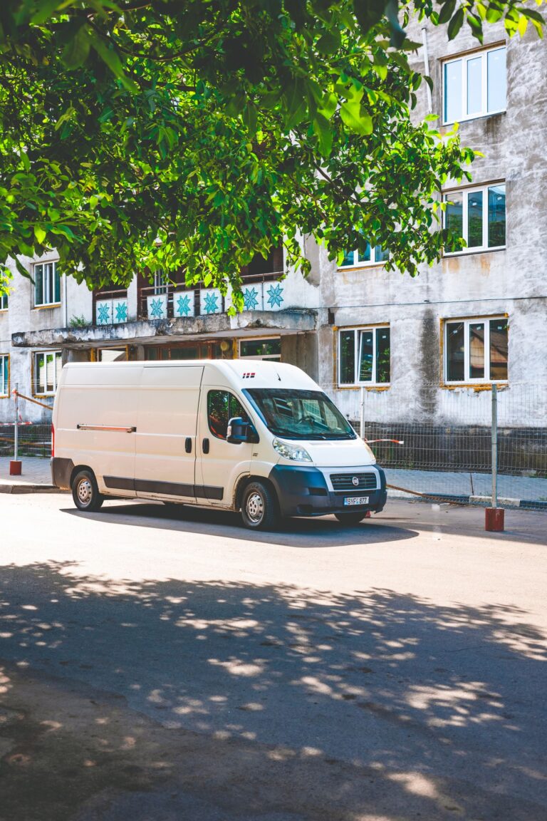 A white work van parked on a city street