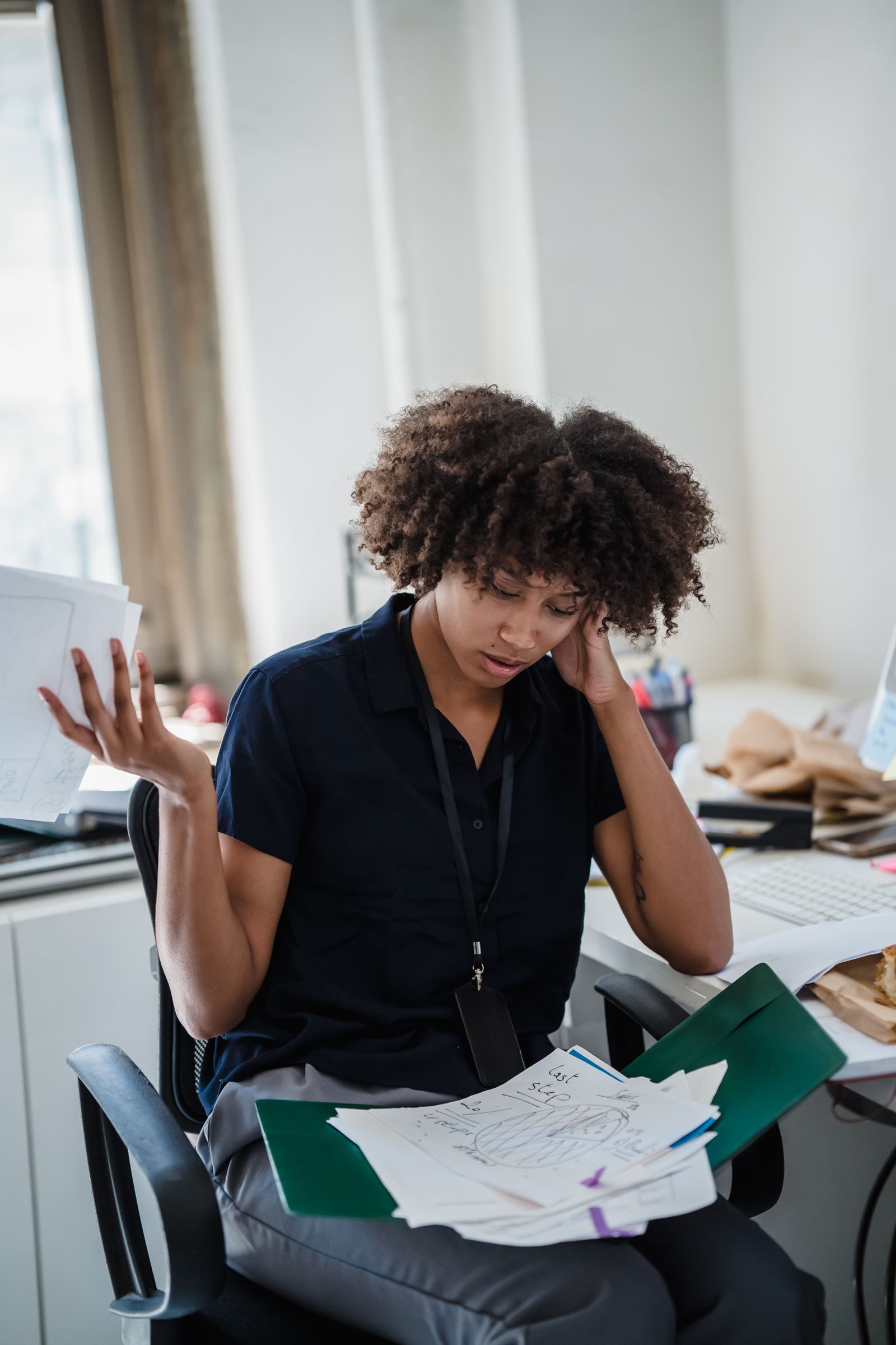 Business owner overwhelmed by paperwork at a cluttered desk