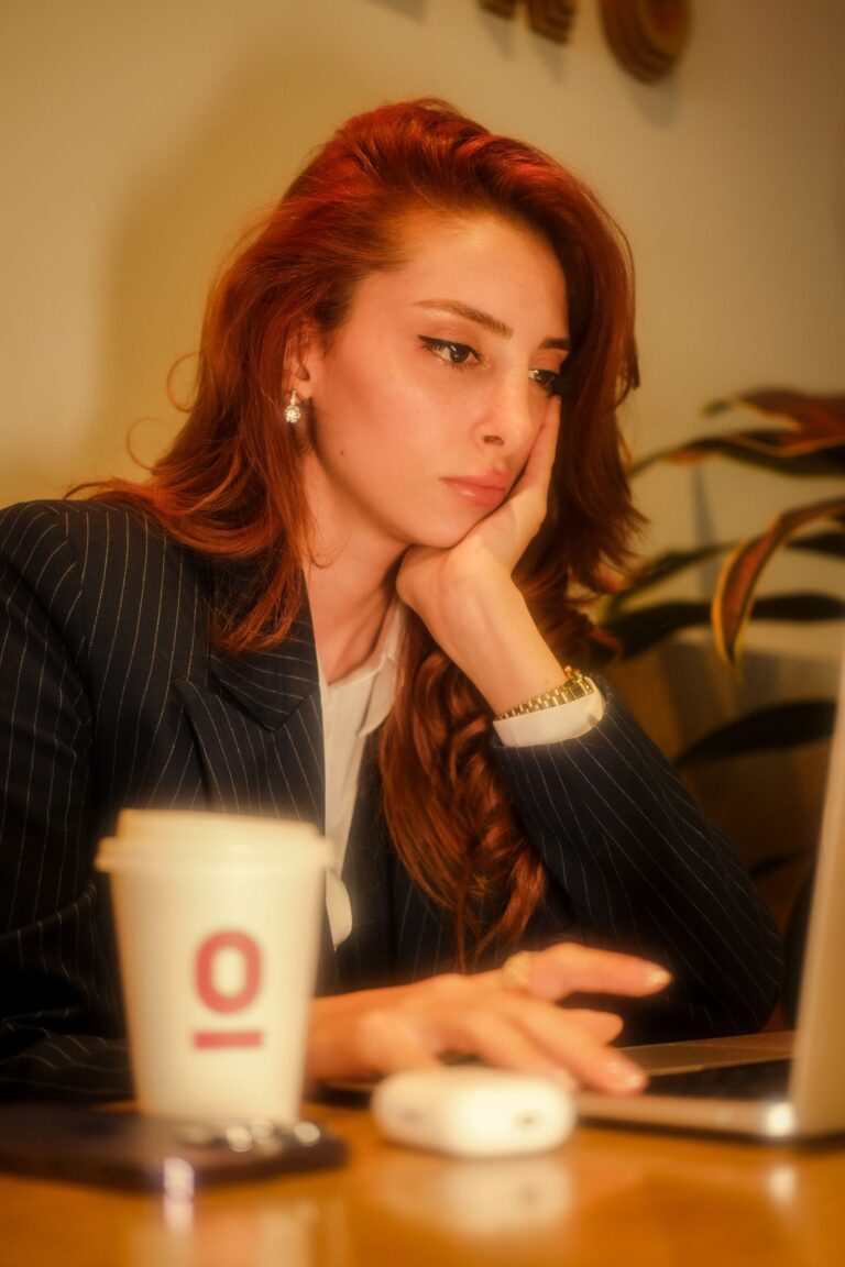 Business owner considering options with a laptop and coffee