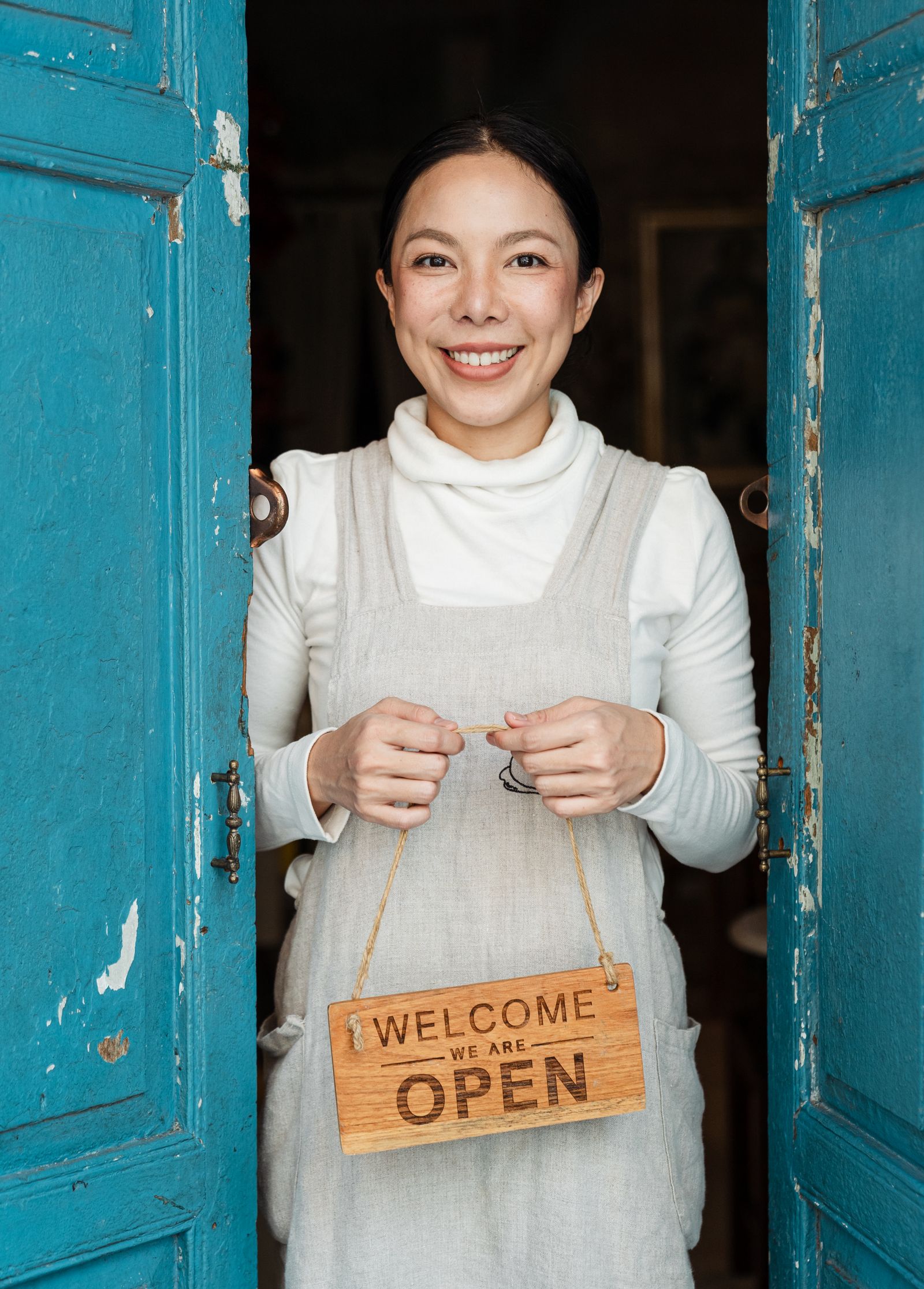 New small business owner holding a We Are Open sign