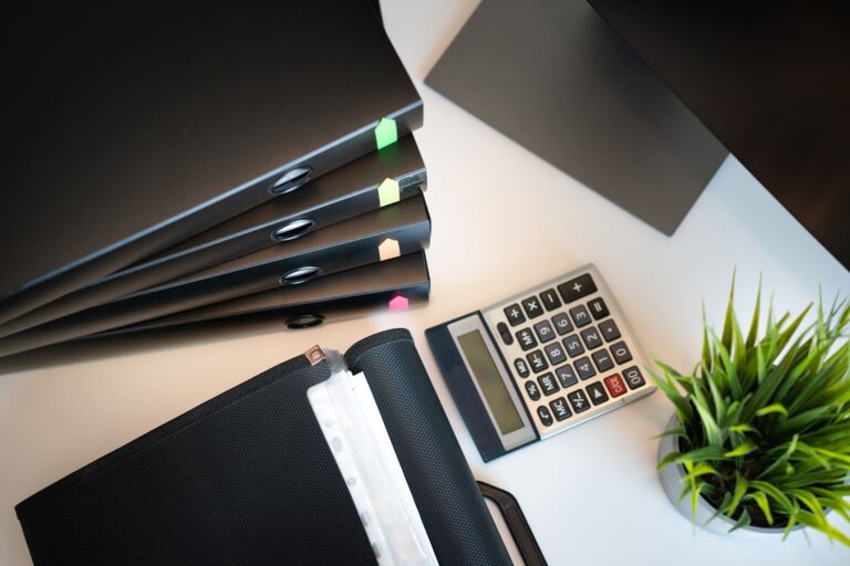 Tidy office desk with files, a calculator, and a plant