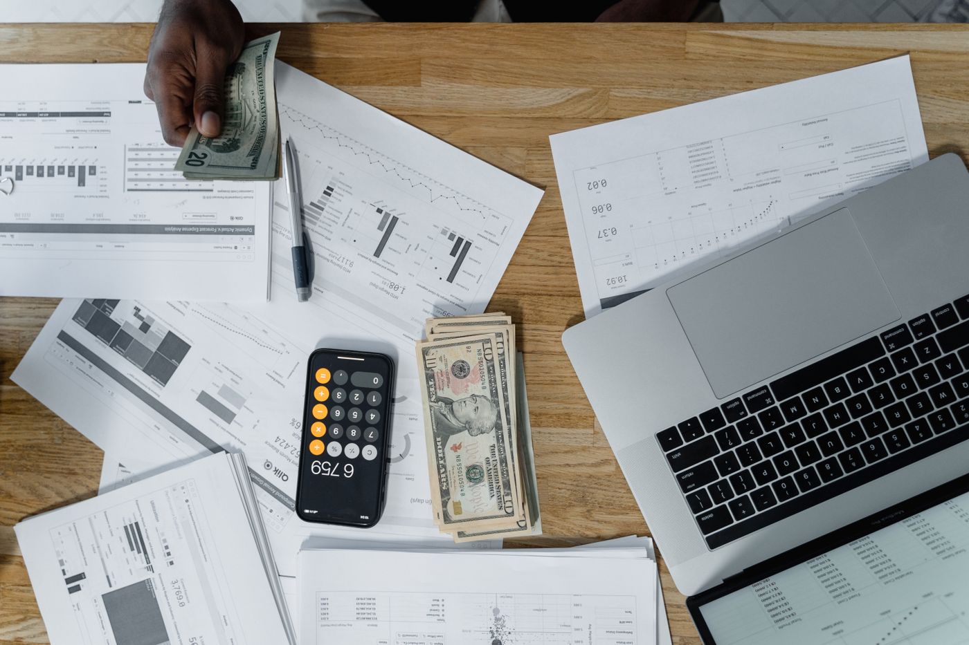 Money, a calculator, and financial documents on a desk