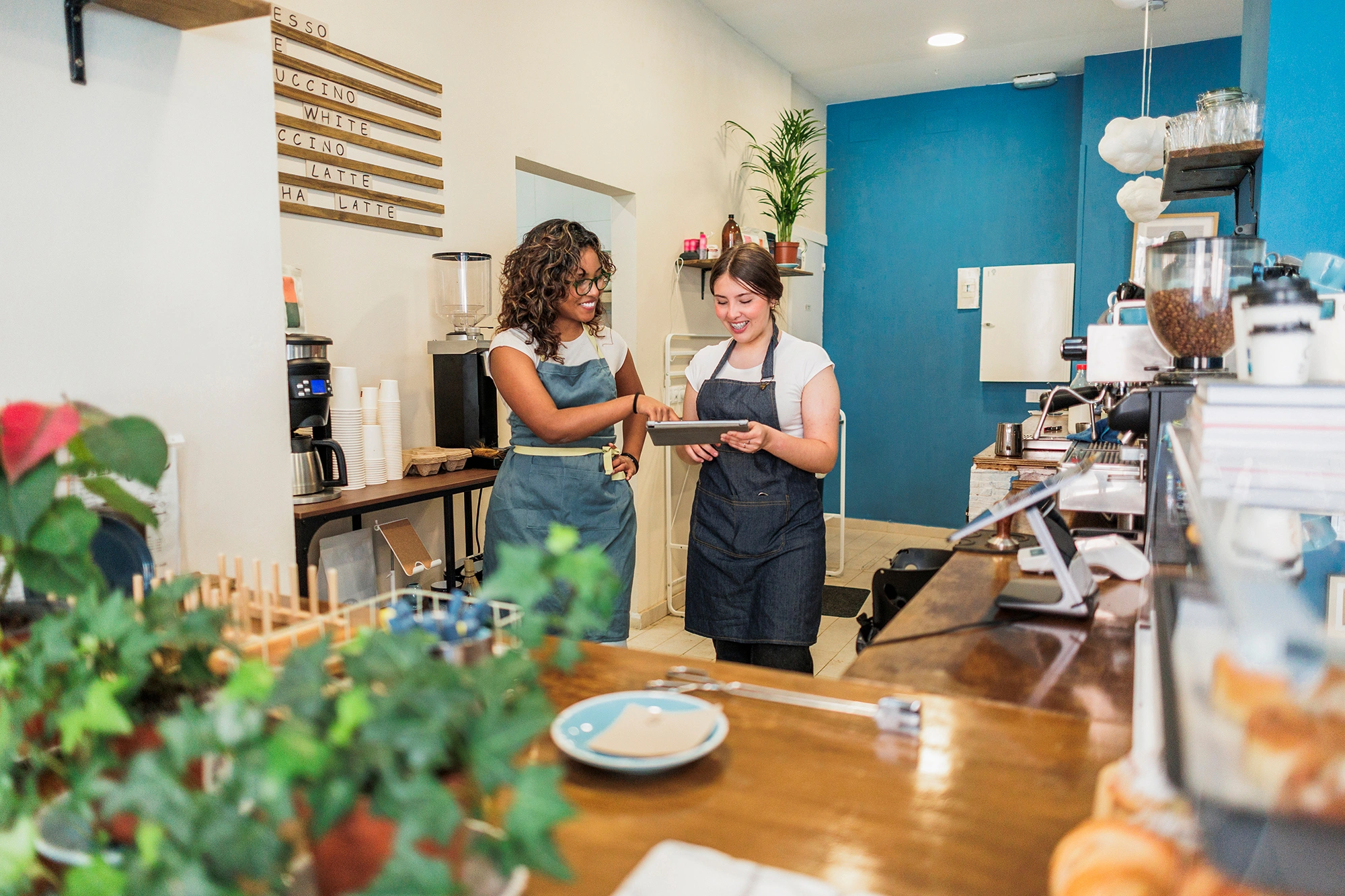 Two cafe owners checking orders together on a tablet